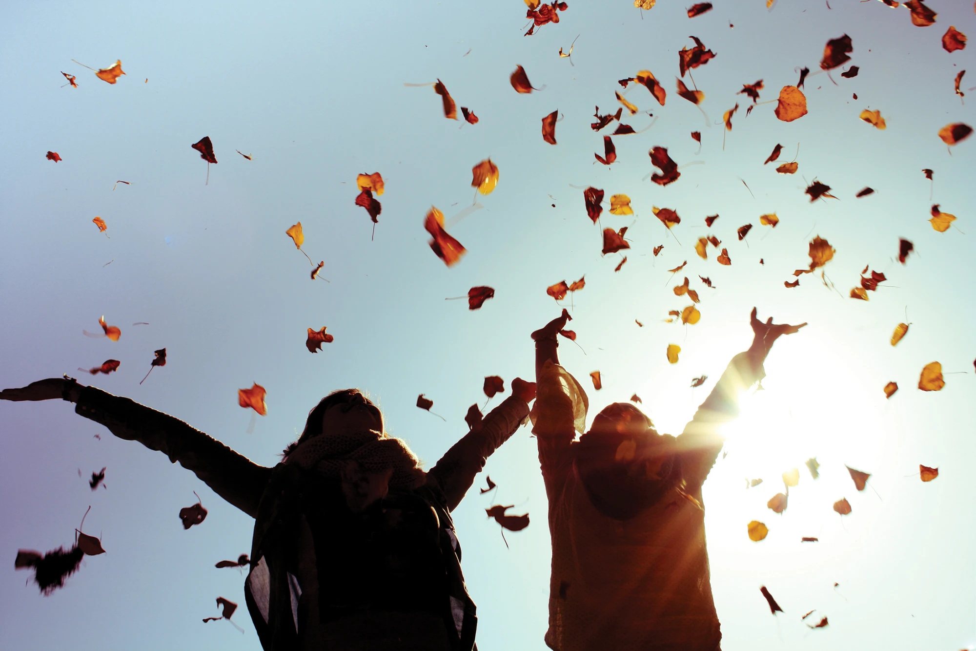 Paar wirft Laub in die Luft